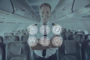 godere il tuo volo digitalmente composto icona impostato al di sopra di un' immagine di allegro pilota con braccia attraversato in piedi dentro aereo foto