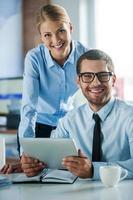 fiducioso attività commerciale esperti. Due allegro giovane persone nel vestito formale sorridente e guardare a telecamera mentre Lavorando insieme foto