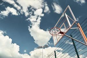 pallacanestro all'aperto. tiro di pallacanestro cerchio con cielo nel il sfondo all'aperto foto