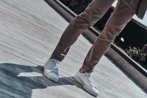 moda inizia con scarpe. avvicinamento di moderno uomo nel bianca scarpe in piedi all'aperto foto