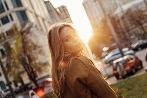 bellezza nel città. attraente giovane donna guardare a telecamera mentre in piedi all'aperto foto