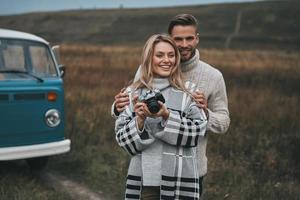 esplorando il mondo insieme. bellissimo giovane donna guardare lontano e sorridente mentre in piedi con sua fidanzato all'aperto foto