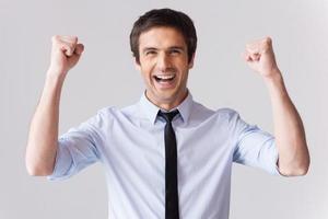 contento uomo d'affari. bello giovane uomo nel camicia e cravatta Esprimere a gesti e sorridente mentre in piedi contro grigio sfondo foto