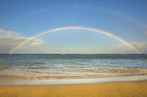 doppio arcobaleno sull'oceano vicino alla spiaggia foto