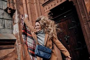 tempo per divertimento. giocoso giovane donna guardare lontano e sorridente mentre salto all'aperto foto