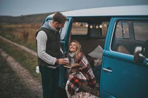 semplice gioia di essere nel amore. bello giovane uomo dando un' boccale per il suo fidanzata mentre godendo loro strada viaggio foto