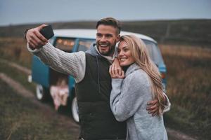 cattura contento momento. bellissimo giovane coppia assunzione autoscatto e sorridente mentre godendo loro strada viaggio foto