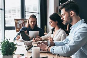 appassionato di attività commerciale. giovane moderno colleghi nel inteligente casuale indossare Lavorando mentre la spesa tempo nel il ufficio foto