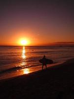 silhouette di un' surfer a tramonto foto