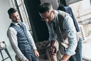 ordine particolari. Due giovane alla moda uomini avendo un' discussione mentre in piedi nel laboratorio foto