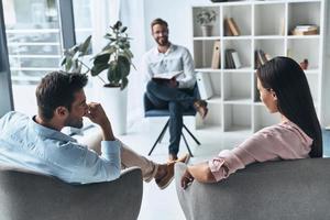 io può vedere un' progresso Qui giovane sposato coppia parlando mentre seduta su il terapia sessione con psicologo foto