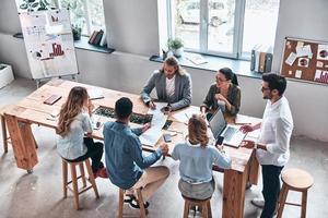 ricerca per giusto decisione. superiore Visualizza di moderno giovane persone discussione attività commerciale mentre Lavorando nel il ufficio foto