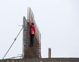 costruzione luogo. il lavoratore esegue opera a altezza. foto