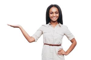 copia spazio su sua mano. bellissimo giovane africano donna Tenere copia spazio e sorridente mentre in piedi contro bianca sfondo foto