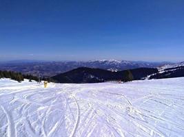 sciare pendenza prospiciente montagne e abete foresta contro blu cielo, kopaonik, Serbia foto