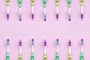 un' lotto di spazzolini da denti menzogna su un' pastello rosa sfondo foto