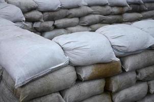 sfondo di molti sporco sabbia borse per alluvione difesa. protettivo sacchetto di sabbia barricata per militare uso. bello tattico bunker foto