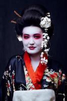 geisha in kimono sul nero foto