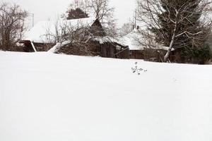 innevato di legno rustico case nel villaggio foto