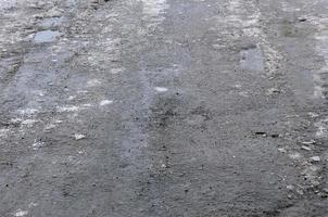 danneggiato asfalto strada con buche causato di congelamento e scongelamento cicli durante il inverno. povero strada foto