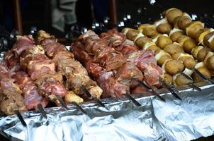 crudo carne e patate siamo piantato su metallo spiedini. il processi di cucinando shish kebab. russo e ucraino campo cibo foto