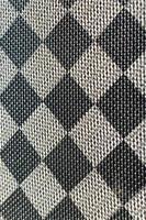 plastica struttura nel il modulo di un' molto piccolo stoffa legame, dipinto nel nero e grigio nel il stile di un' scacchiera. macro tiro foto