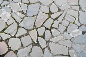 il struttura di il pietra strada, marciapiede, muri di grande grigio vecchio medievale il giro forte pietre, ciottoli. il sfondo foto