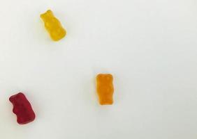 gommoso orsi su un' bianca Opaco sfondo. rosso, giallo e arancia orso menzogna su il tavolo. caramelle di nostro proprio produzione. dolci per decorazione torte e pasticcini foto