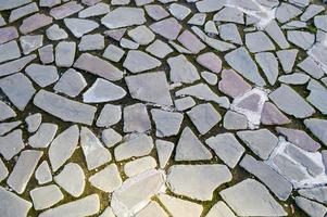 il struttura di il pietra strada, marciapiede, muri di grande grigio vecchio medievale il giro forte pietre, ciottoli. il sfondo foto