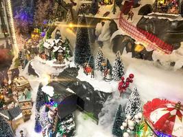 nuovo anni paesaggio. giocattolo miniatura per il vetrina. multilivello composizione con un' montagna e poco le persone. mondo dietro a bicchiere. shopping centro commerciale Natale decorazione foto