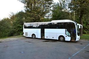 bianca turista autobus per escursioni. il autobus è parcheggiata nel un' parcheggio lotto vicino il parco foto