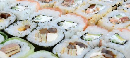 avvicinamento di un' lotto di Sushi rotoli con diverso ripieni. macro tiro di cucinato classico giapponese cibo. sfondo Immagine foto