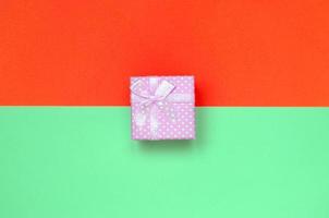 piccolo rosa regalo scatola menzogna su struttura sfondo di moda pastello turchese e rosso colori carta foto