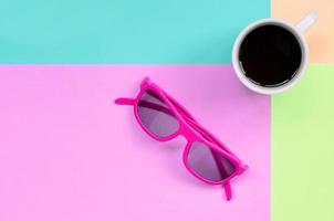 piccolo bianca caffè tazza e rosa occhiali da sole su sfondo di moda pastello rosa, blu, corallo e lime colori foto