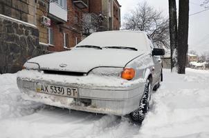 Kharkov, Ucraina - dicembre 4, 2016 un' parcheggiata auto sotto un' di spessore strato di neve. conseguenze di un' forte e inaspettato nevicata nel Ucraina foto