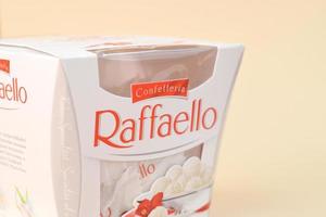 Kharkov, Ucraina - dicembre 9, 2020 Raffaello caramelle su beige sfondo. Raffaello è un' sferico Noce di cocco mandorla confezione quello italiano fabbricante ferrero portato per il mercato nel 1990 foto