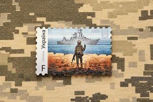 ternopil, Ucraina - settembre 2, 2022 famoso ucraino timbro postale con russo nave da guerra e ucraino soldato come di legno souvenir su esercito camuffare uniforme foto