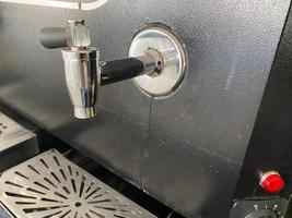brillante metallo rubinetti e tubi per scrosciante caffè a partire dal un' caffè macchina. apparato per caldo bevande foto