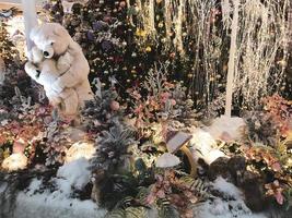 Natale decorazioni. un' giocattolo polare orso sta Il prossimo per un artificiale Natale albero. madre orso detiene sua cucciolo nel sua braccia. Natale vigilia carino giocattoli per bambini foto