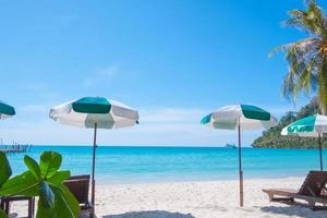 tropicale spiaggia sfondo come estate paesaggio con spiaggia sedie e bellissimo mare Visualizza foto