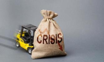 giallo carrello elevatore a forca camion può non sollevamento il Borsa con il iscrizione crisi. economico crisi, stagnazione e recessione di il economia. declino nel produzione, richiesta e acquisto potenza. mancanza di supporto foto