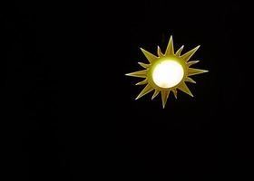 lampada nel il forma di il sole su nero sfondo foto