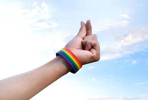 mano di umano quale ha arcobaleno polsino e fare mini cuore o amore cartello di dita, concetto per presentazione amore per LGBTQ generi per tutti persone chi aveva Genere diversità in giro il mondo. foto