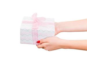 donna mani dare avvolto Natale o altro vacanza fatto a mano presente nel colorato carta con rosa nastro. isolato su bianca sfondo, superiore Visualizza. ringraziamento regalo scatola concetto foto