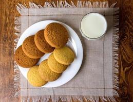 cibo, cibo spazzatura, culinario, cottura al forno e mangiare concetto - vicino su fiocchi d'avena biscotti e latte bicchiere foto