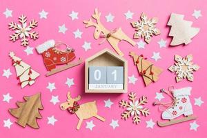 superiore Visualizza di calendario, rosa sfondo decorato con festivo giocattoli e Natale simboli renne e nuovo anno alberi. il primo di gennaio. vacanza concetto foto