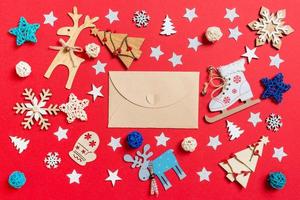 superiore Visualizza di mestiere Busta, vacanza giocattoli e decorazioni su rosso Natale sfondo. nuovo anno tempo concetto foto