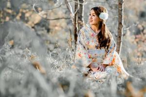 viaggio , vacanza nel Giappone concetto, giovane asiatico donna indossare tradizionale giapponese chimono nel il parco nel il mattina. foto