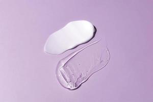 lenire crema lozione idratante gel sbavatura su viola sfondo. cura della pelle e corpo bellezza Prodotto. liquido gel cosmetico macchie foto