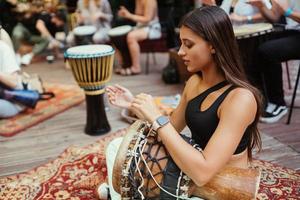 un' giovane bellissimo donna giochi un' mano tamburo foto